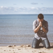 Man praying on a beach about God's will